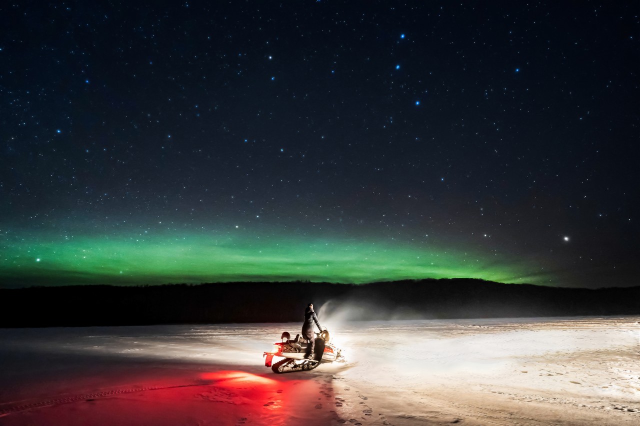Donna in motoslitta sotto il cielo stellato